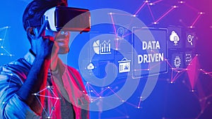 Young man in virtual reality headset exploring data visualization and technology trends in a vibrant digital environment