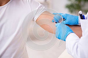 Young man visiting experienced doctor dermatologist