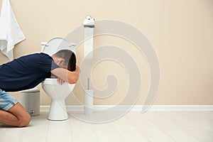 Young man vomiting in toilet bowl