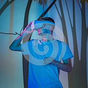 Young man with a VR headset, a simulation of being in the forest