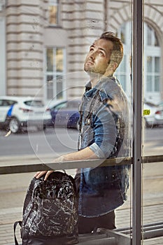 Young man is waiting for bus