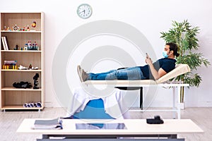 Young man waiting for doctor during pandemic in hospital