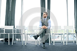 Young man waiting for job interview indoors.