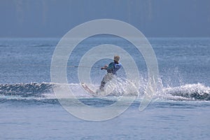 Young man wakeboarding on Cultus lake on a sunny day.