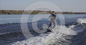 Young man wakeboarding on river