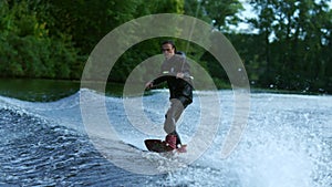 Young man wakeboarding on river wave. Wake boarding rider