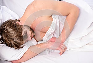 A young man waking up in bed and stretching his arms. Young man stretching while waking up in the morning. People