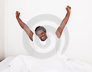 Young man waking up at bedroom