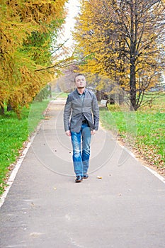 Young man walking in autumn park