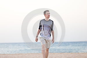 Young man walking on the beach