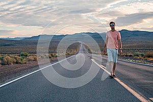 Young man walking down the endless road