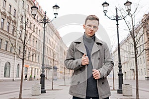Young man walking down street, autumn or winter cold day. Outdoors, outside.