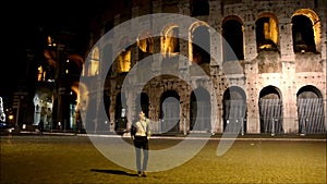 Young man walking in front of Colosseum in Rome, Italy