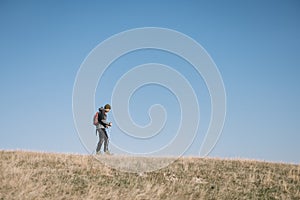 Young man walking on a hill with blue heavens