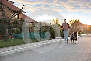 Young man walking his Caucasian Shepherd dog