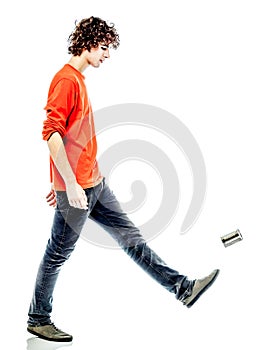 Young man walking kicking tin can side view