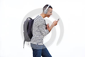 Young man walking with mobile phone and listening to music with headphones