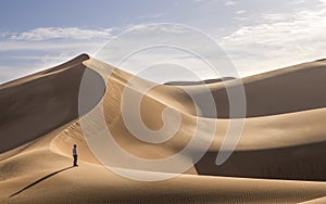 Young man walking in the sand dunes of Liwa desert