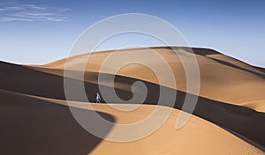 Young man walking in the sand dunes of Liwa desert