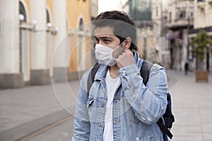 Young man is walking on the street with a protective mask