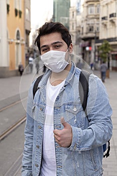 Young man is walking on the street with a protective mask