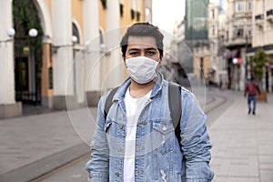 Young man is walking on the street with a protective mask