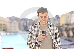 Young man walking and using smart phone