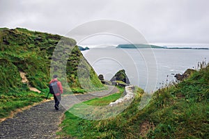 Young man walks along pathway surrounded by irish landscape