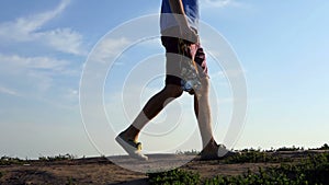 Young man walks with a lot of medals on a lane in summer