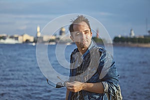 Young man walks near Neva river