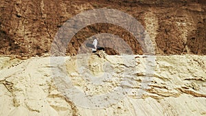 Young man walks witn sandboard in desert