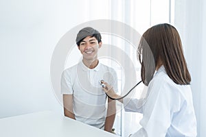 A young man was examined by a female doctor with a stethoscope on his chest