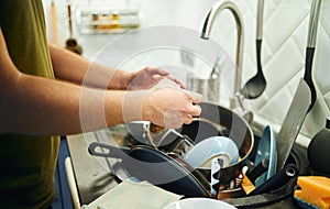 Young man washing dishes in the kitchen.