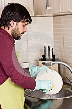 Young man washing dishes