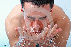 Young man washing face.