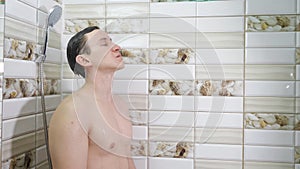 Young man washing hair under shower