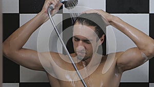 Young man washing hair under shower