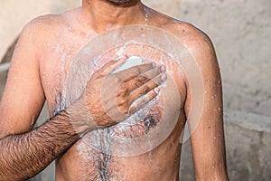 A young man is washing his body by a beauty soap