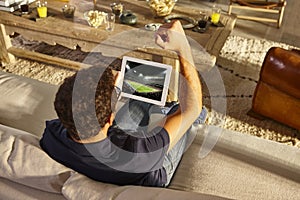 Young man watching a football g on a couch. Home recreation