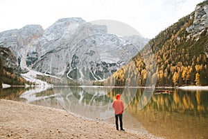 Young man watching sunrise at Lago di Braies, South Tyrol, Italy