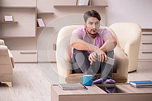 Young man watching tv at home during pandemic