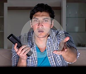 Young man watching tv late at night