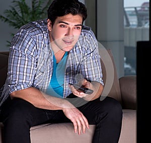 Young man watching tv late at night