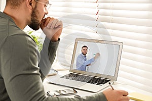 Young man watching video at desk. Online learning