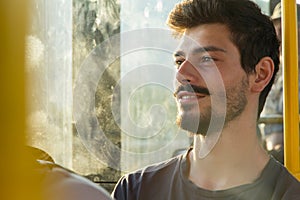 Young man watching through window in bus