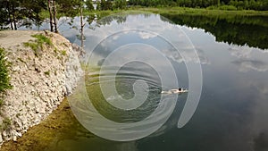 Young man water jump lake drone aerial top view