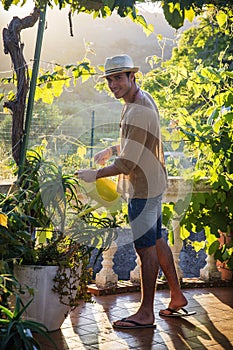 Young man watering plants in garden