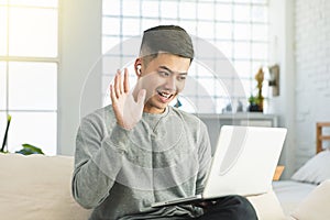 Young man  wear earphone and using video conference  on laptop computer at home