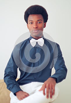 Young man wearing black shirt and white bow tie studio portrait
