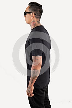 Young man wearing black t shirt  on white background. Young hipster man wearing t shirt and sunglasses in left side view